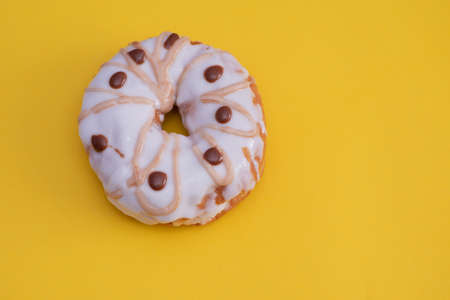 Close up shot of donut isolated against yellow backgroundの写真素材