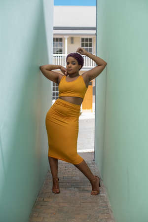 Confident young woman standing between two wallsの写真素材