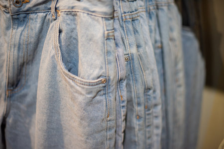 Selection of denim jeans on shelf with selective focus