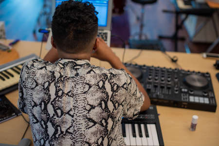Rear view of musician producing at home