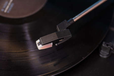 Close up shot on turntable arm hovering above recordの写真素材