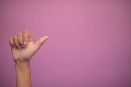 Hand held up showing thumbs up gestureの写真素材
