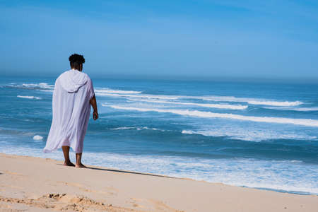 Rear view shot of woman standing and watching the oceanの写真素材