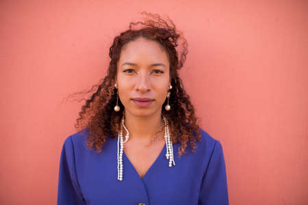 Portrait of young woman against bright colored wallの写真素材