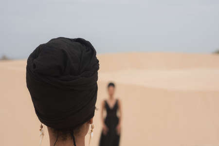 Rear view of woman with headwrap at the beachの写真素材