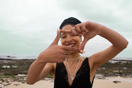 Portrait of happy woman making a frame gesture with her hand