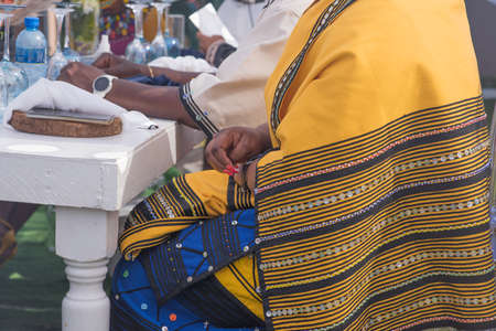 Woman in traditional clothing seen sitting at tableの写真素材