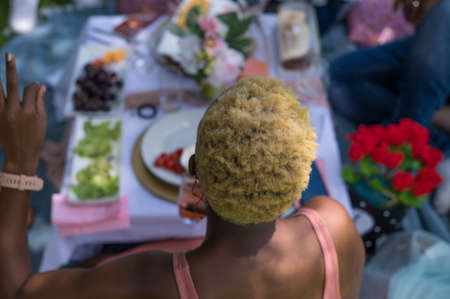 Rear view of woman with colorful hair seated outdoorsの写真素材