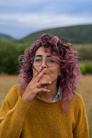 Portrait of woman smoking cannabis joint