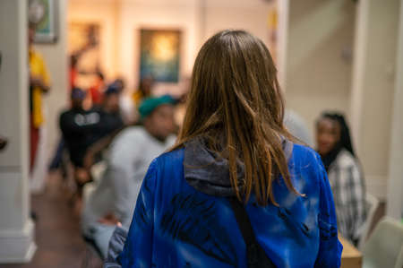 Rear view of woman talking to a group of peopleの写真素材