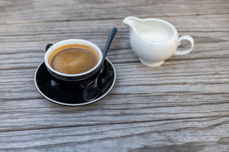 Close up shot of black coffee with milk on side