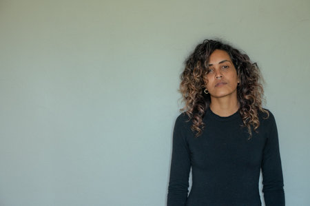 Portrait of woman standing against wall