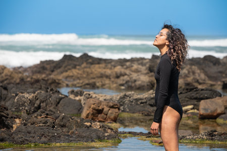 Contemplative woman seen standing by the seaの写真素材