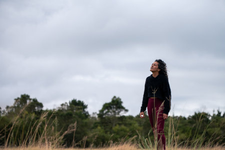 Woman standing in field with vaporizer in handの写真素材