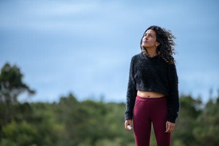 Woman seen standing in nature while looking upの写真素材