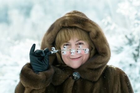 mature woman in a winter forest snow day  の写真素材