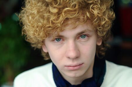 portrait of a young man with curly hairの写真素材