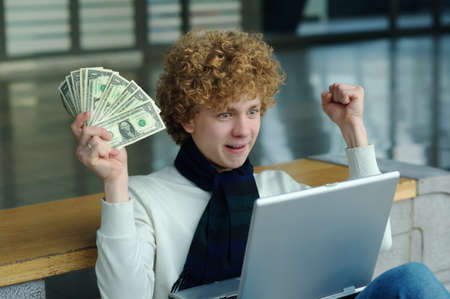 young man with a laptop computer and dollars