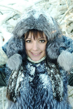 young woman winter day on the background of a snowy forestの写真素材