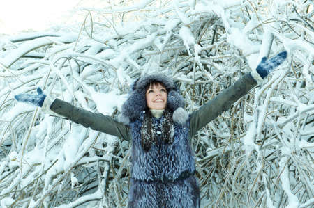 young woman winter day on the background of a snowy forestの写真素材
