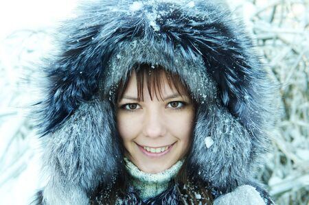 young woman winter day on the background of a snowy forestの写真素材