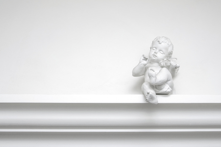 White plaster angel sculpture with a violin on a white backgroundの写真素材