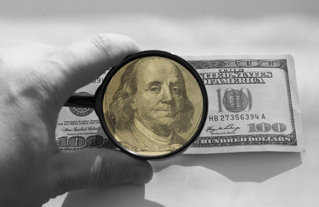 one hundred dollars and magnifying glassの写真素材
