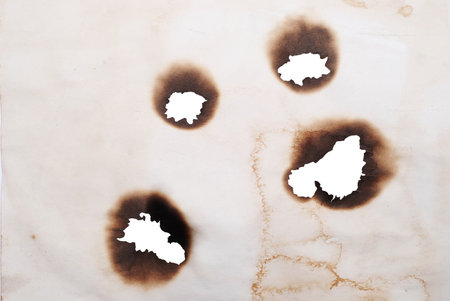 burnt holes in a paperの写真素材