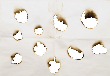burnt holes in a paper isolated on a whiteの写真素材