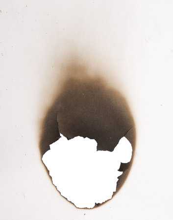 burnt hole in a paperの写真素材