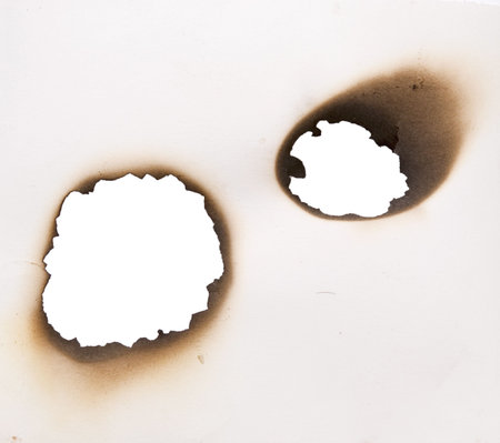 two burnt holes in a paperの写真素材