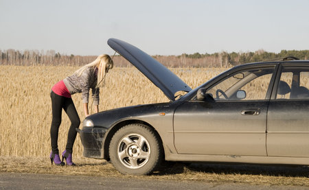 young pretty blonde with her broken car