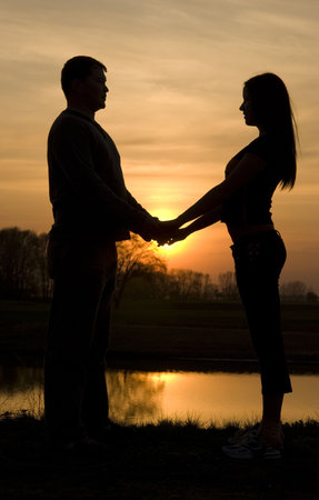 silhouette of a male and female couple at sunsetの写真素材