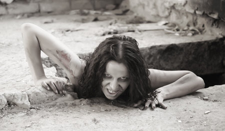 scary woman creeping out of a holeの写真素材