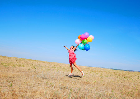 young jumping woman with balloonsの写真素材