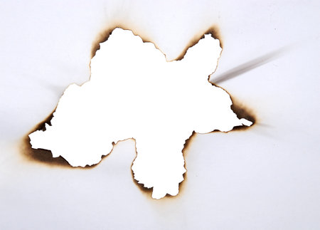 burnt hole in a paperの写真素材