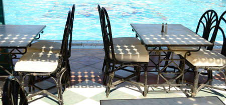 tables and chairs against pool のeditorial素材
