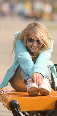portrait of happy sitting teenager on benchの写真素材