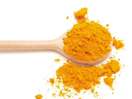 yellow turmeric in wooden spoon on white backgroundの写真素材