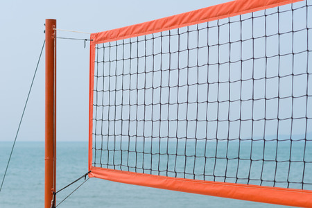 volleyball net at the beach against blue skyの写真素材