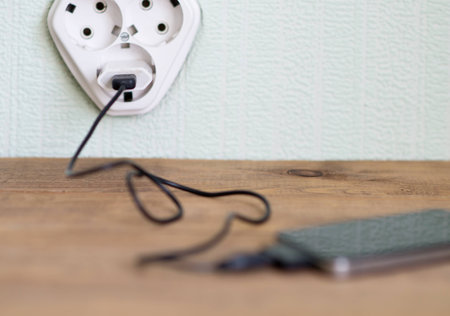 charging mobile phone on wooden table