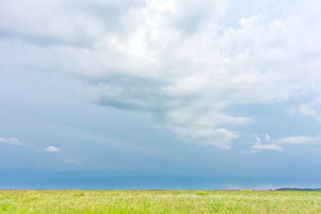 green field and rainy cloudsの写真素材