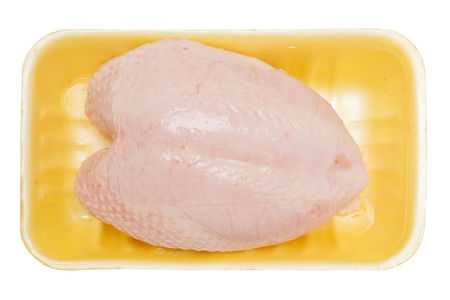 raw chicken breast in yellow plastic tray isolated on white backgroundの写真素材