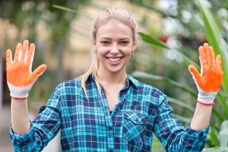 portrait of happy female gardener in greenhouseの写真素材