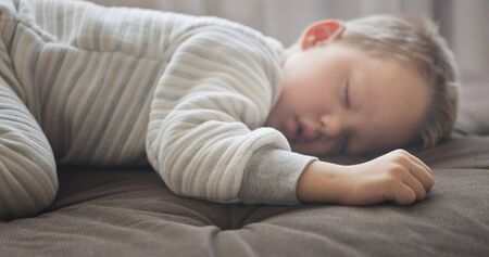 close up shot of cute sleeping boy, focus on handの写真素材