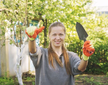 young beautiful female gardener with thumb upの写真素材