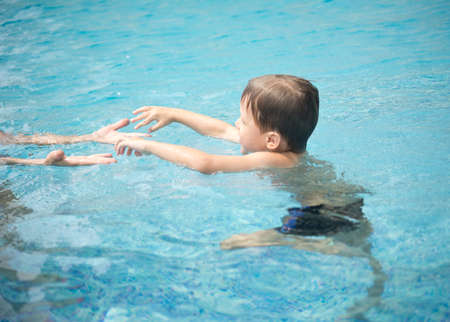boy with his mother in the swimming poolの写真素材
