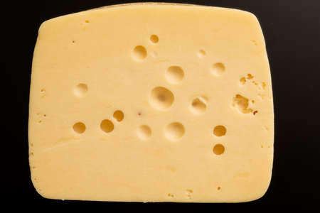 piece of cheese on black backroundの写真素材