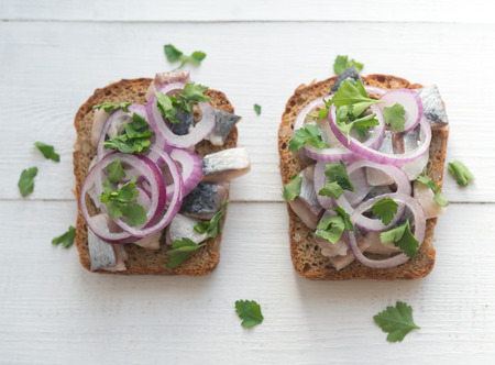 Two open sandwiches with herring, red onion and parsleyの写真素材