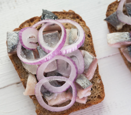 Open sandwich with salt herring and red onionの写真素材